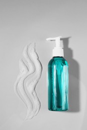 Photo of Dispenser with cleansing foam on light grey background, flat lay. Cosmetic product