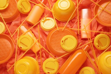 Photo of Different orange plastic items as background, closeup