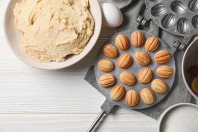 Delicious walnut shaped cookies and ingredients on white wooden table, flat lay