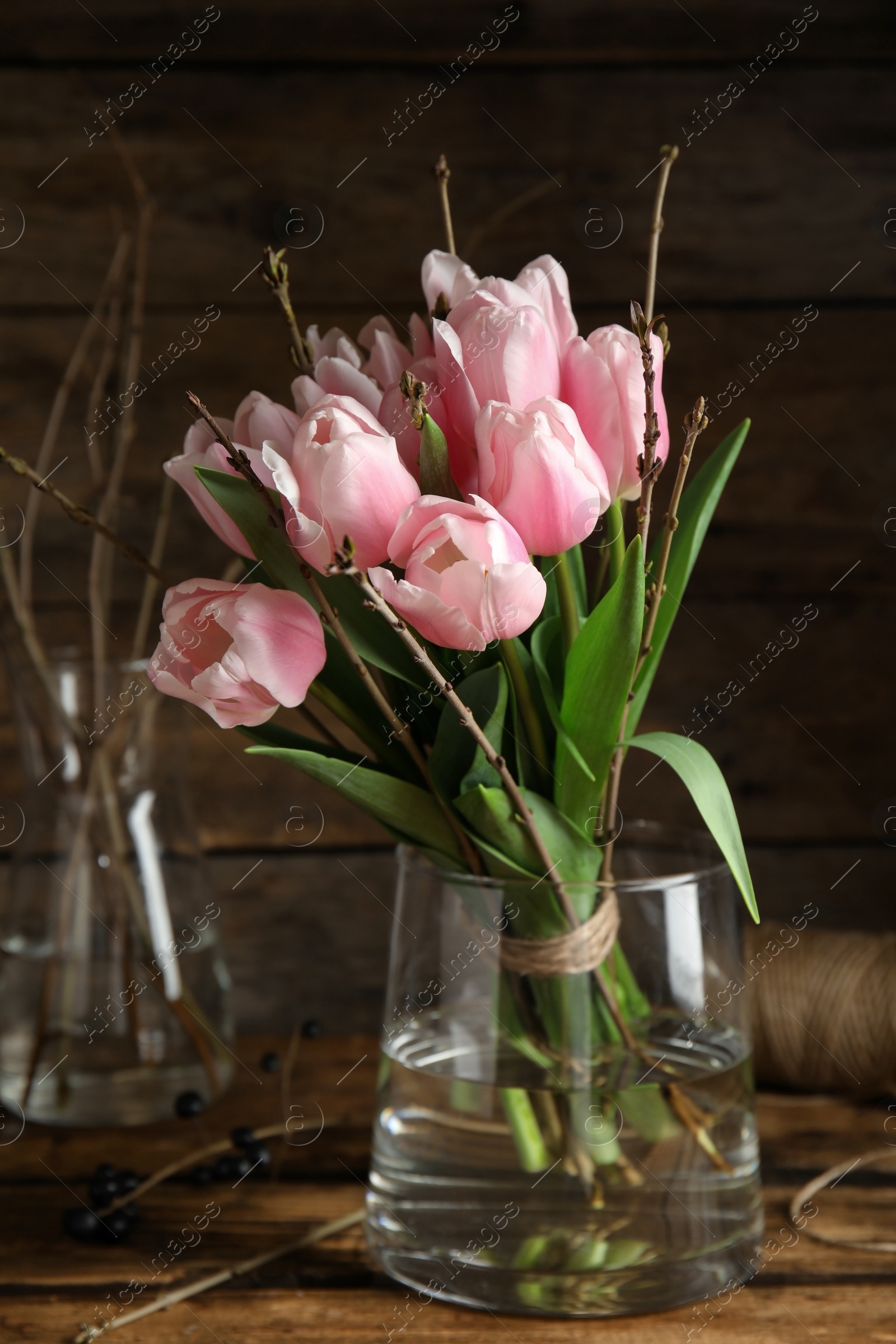 Photo of Beautiful bouquet of spring pink tulips on wooden table