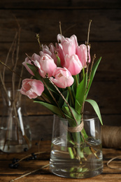 Photo of Beautiful bouquet of spring pink tulips on wooden table