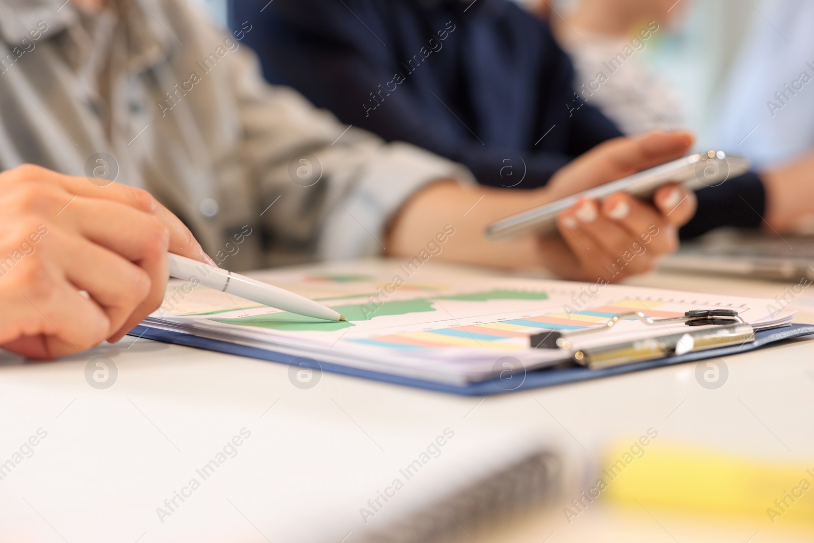 Photo of Employees working with charts at table, closeup. Startup project