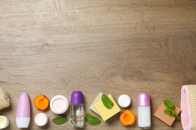 Photo of Flat lay composition with natural roll-on deodorants on wooden table. Space for text