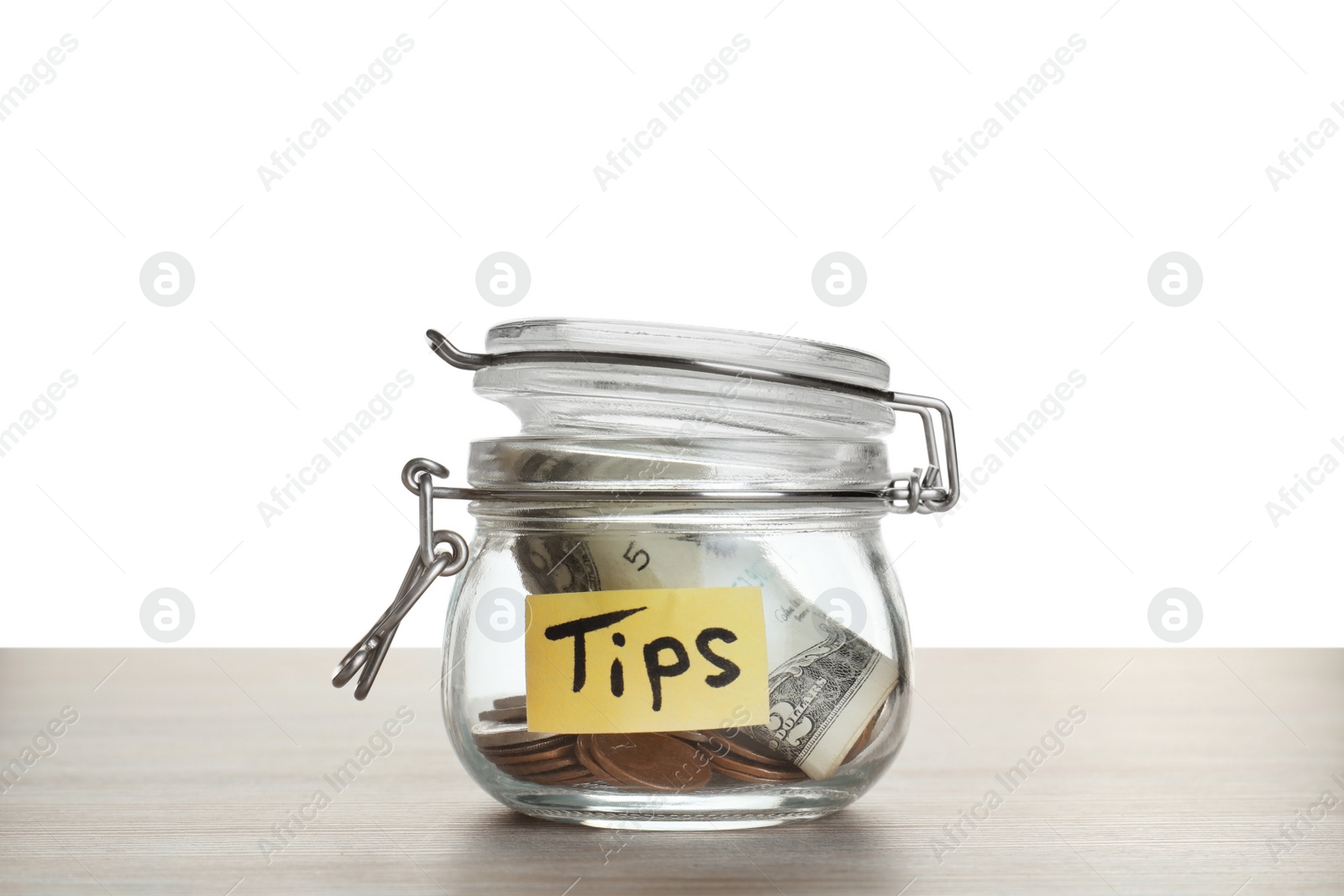 Photo of Tip jar with money on wooden table against white background