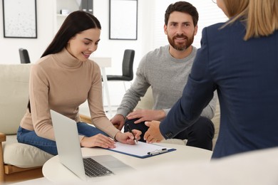 Photo of Couple signing contract in real estate agent's office
