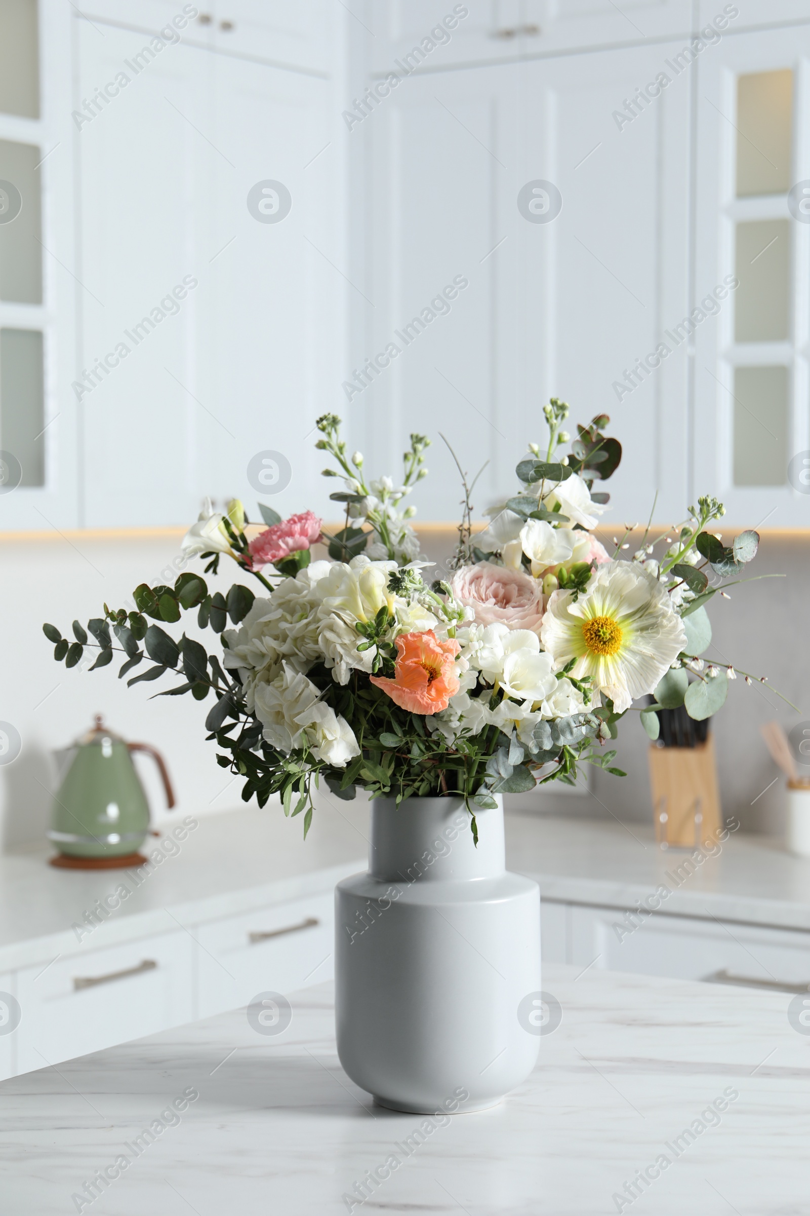 Photo of Bouquet of beautiful flowers on white table indoors
