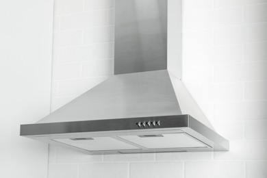 Photo of Modern range hood on white brick wall in kitchen