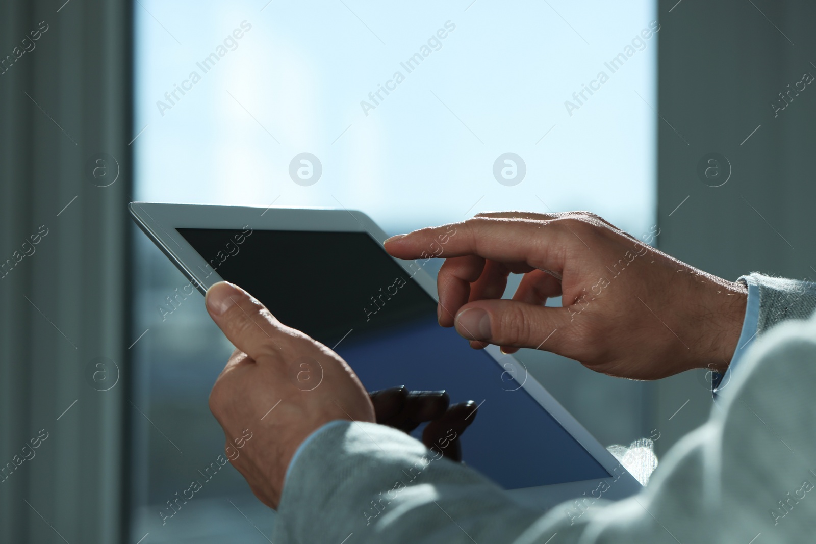 Photo of Closeup view of man using new tablet indoors