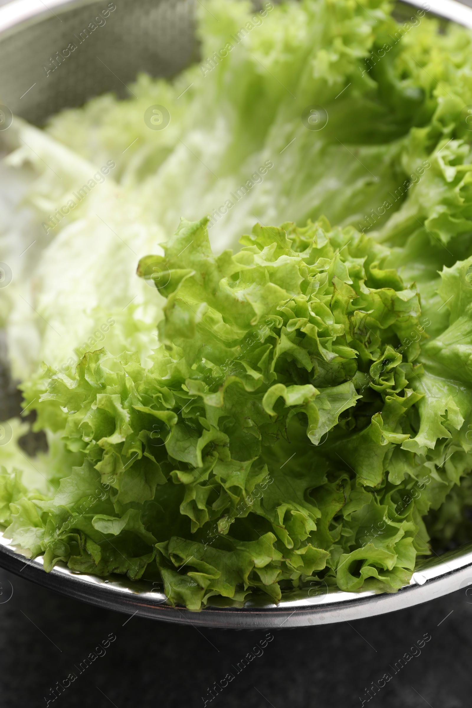 Photo of Fresh lettuce on stone table, closeup. Salad greens