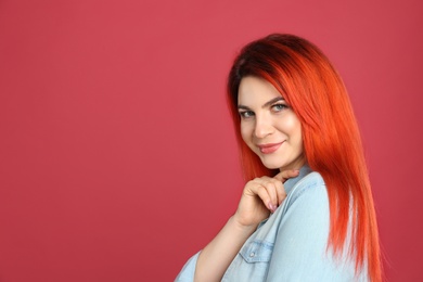 Photo of Young woman with bright dyed hair on red background. Space for text