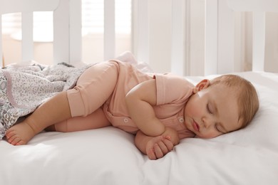 Photo of Cute little baby sleeping in soft crib at home