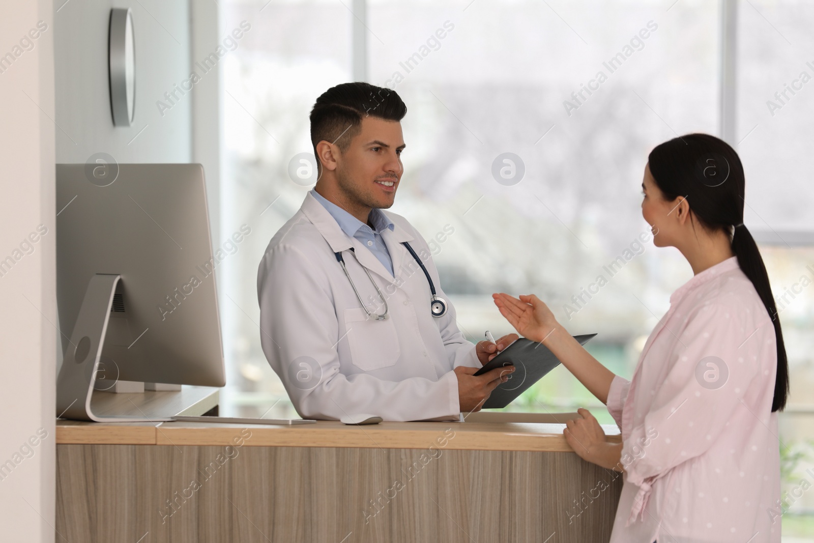 Photo of Doctor working with patient at reception in hospital