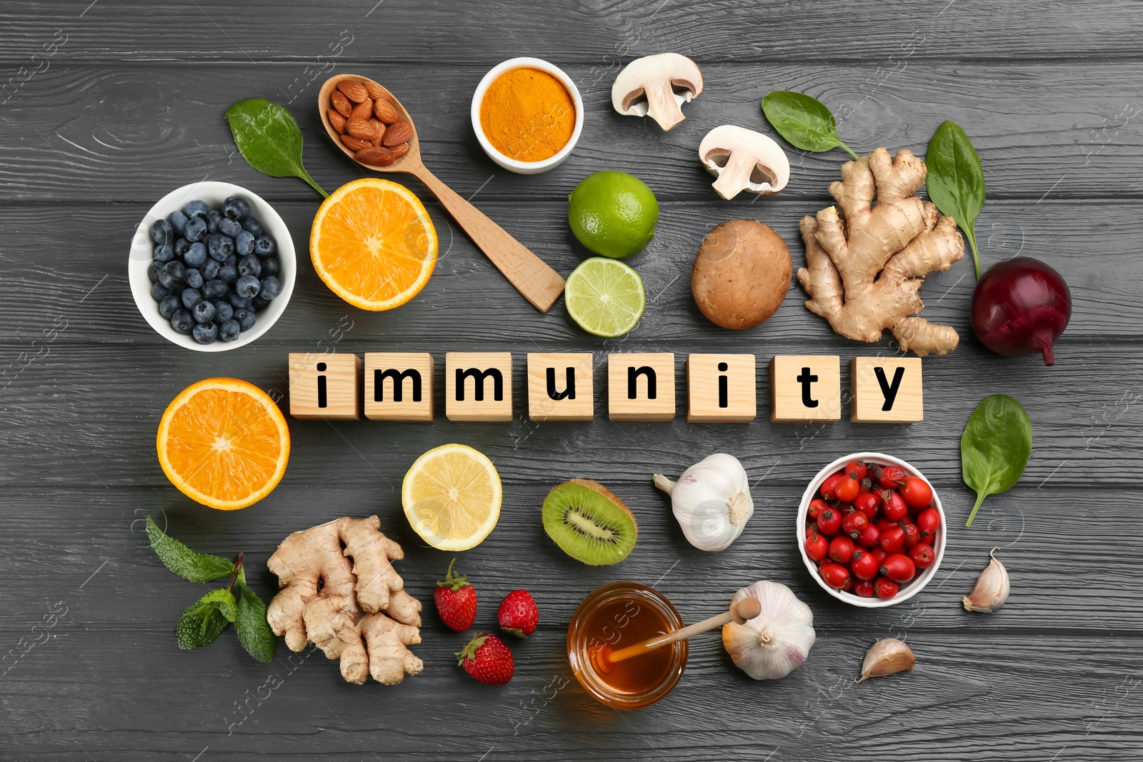 Photo of Cubes with word Immunity and fresh products on grey wooden table, flat lay