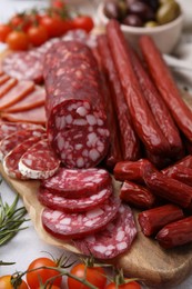 Different types of delicious sausages and ingredients on light grey table, closeup