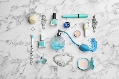 Photo of Flat lay composition with perfume bottles, jewelry and decorative cosmetics on white marble table
