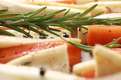 Photo of Slices of parsnip and carrot with rosemary, closeup