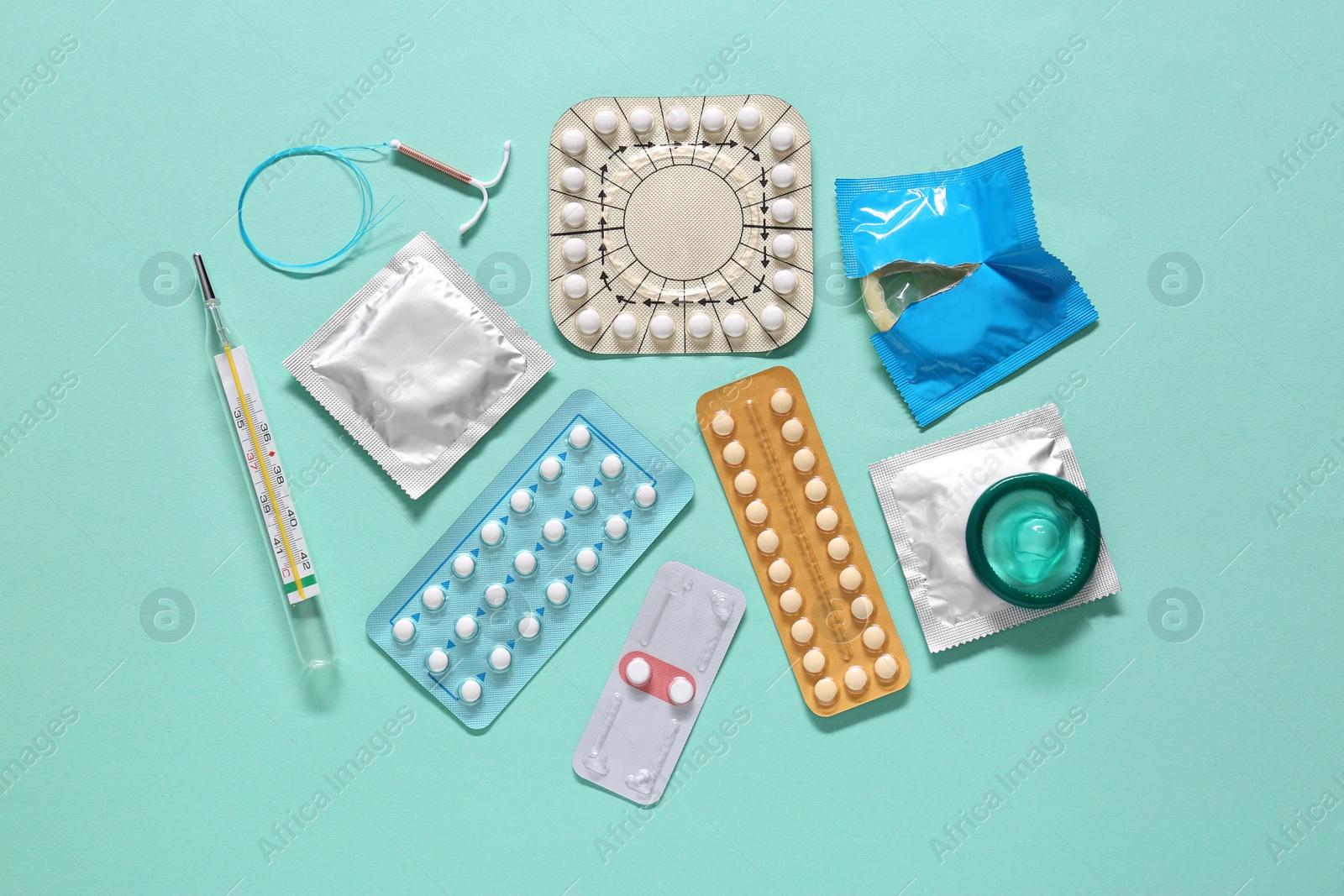 Photo of Contraceptive pills, condoms, intrauterine device and thermometer on turquoise background, flat lay. Different birth control methods