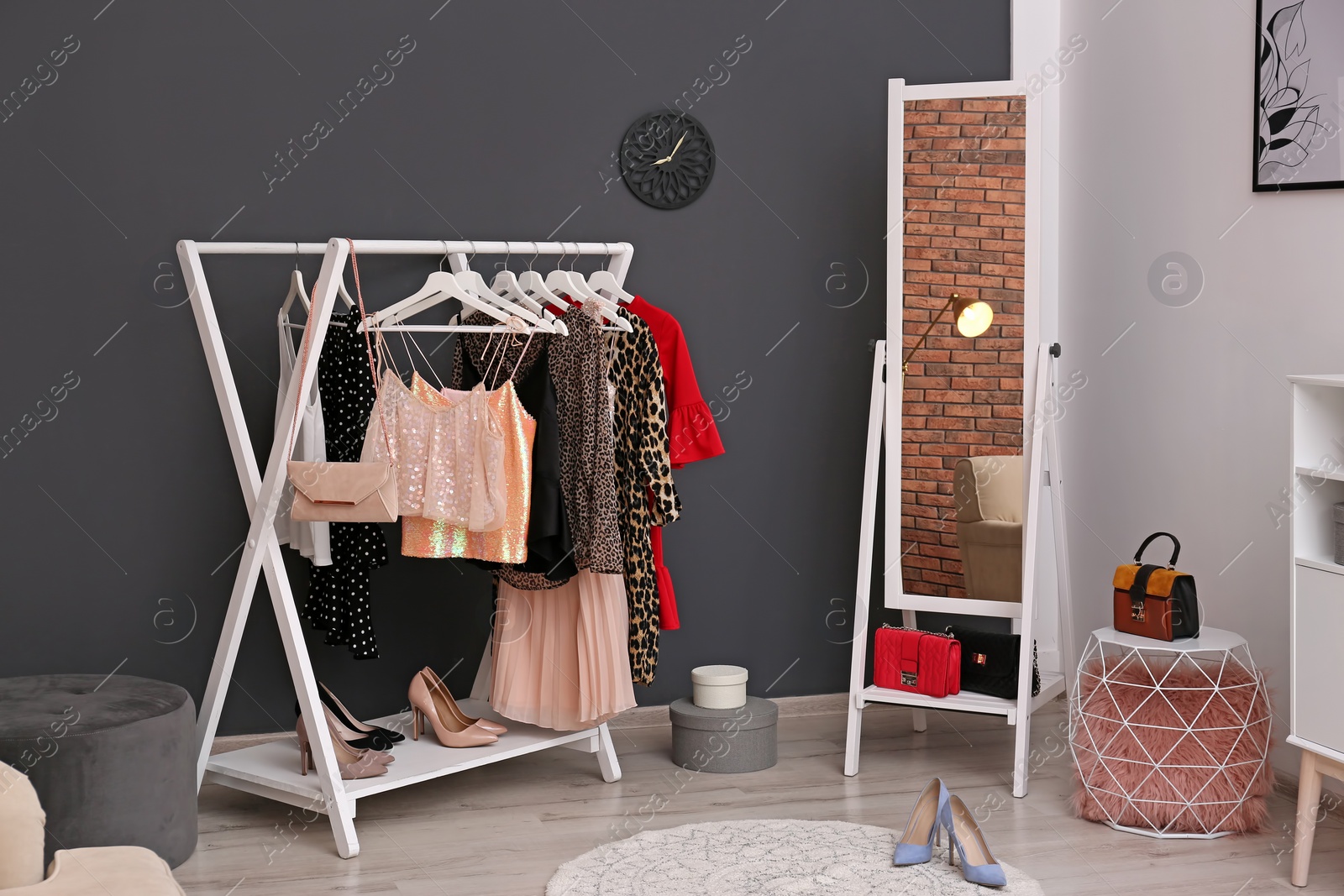 Photo of Wardrobe rack with women's clothes and shoes in dressing room