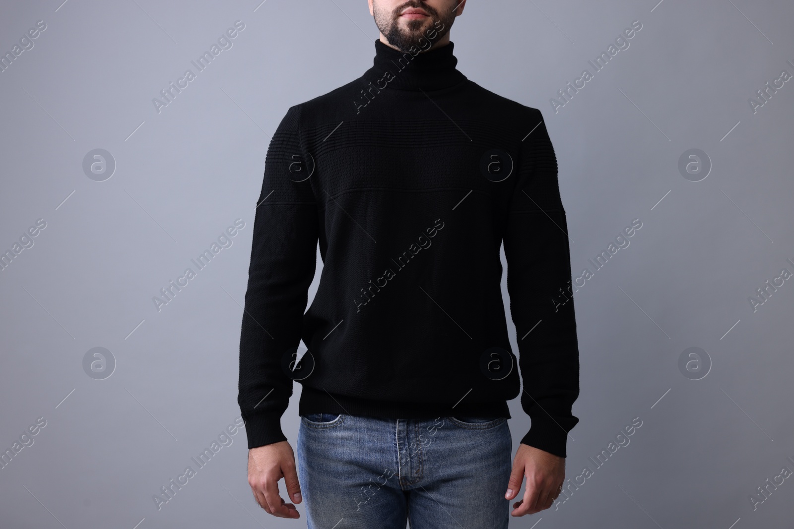 Photo of Man in stylish black sweater on grey background, closeup