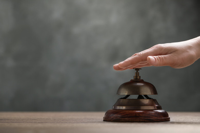 Photo of Man ringing hotel service bell at table, closeup. Space for text