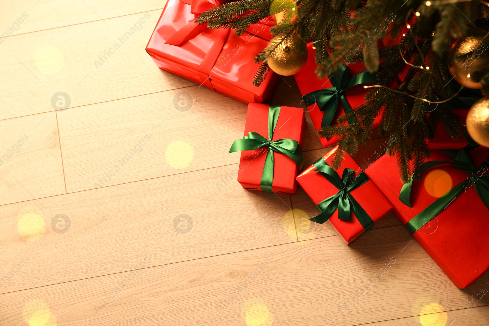 Photo of Many beautifully wrapped gift boxes under Christmas tree indoors, above view