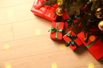 Photo of Many beautifully wrapped gift boxes under Christmas tree indoors, above view