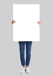 Photo of Woman holding blank poster on light grey background