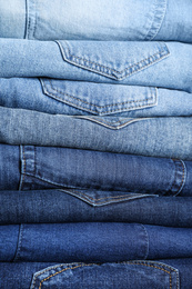 Stack of different jeans as background, closeup