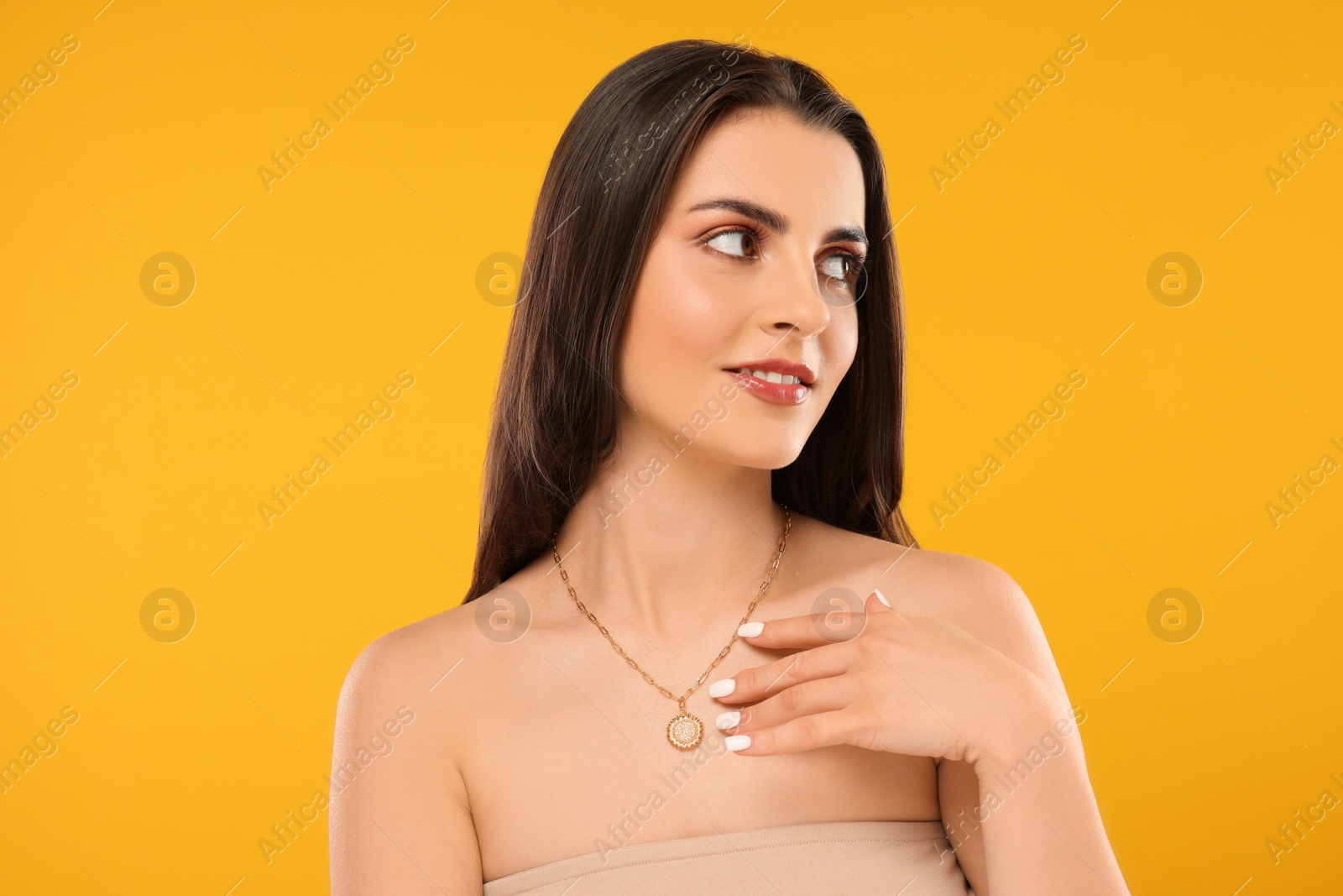 Photo of Beautiful woman with elegant necklace on orange background