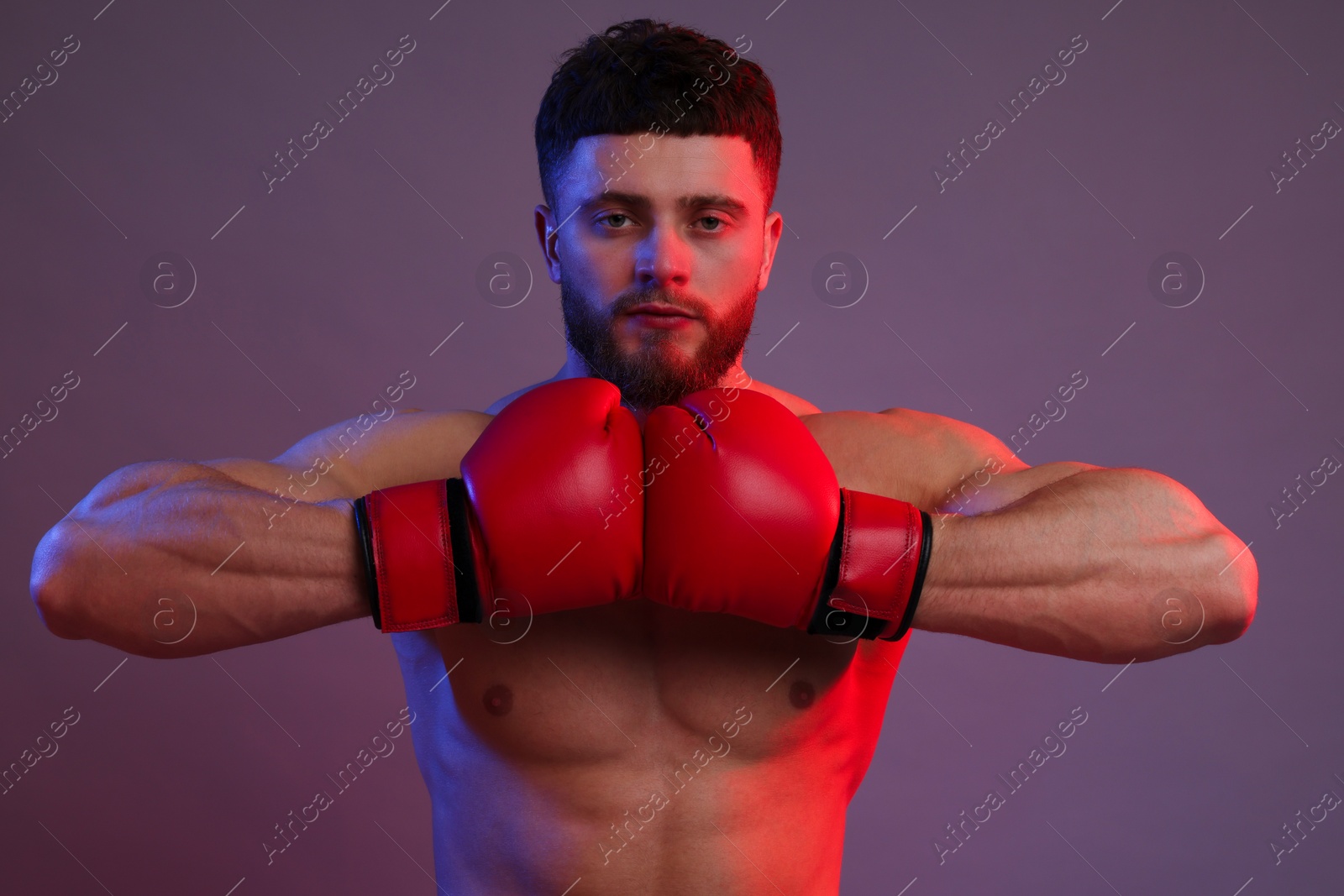 Photo of Man in boxing gloves on color background