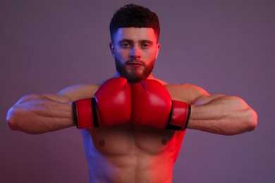 Photo of Man in boxing gloves on color background
