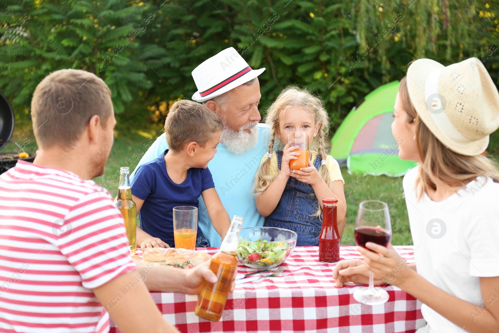 Photo of Happy family having barbecue in park on sunny day