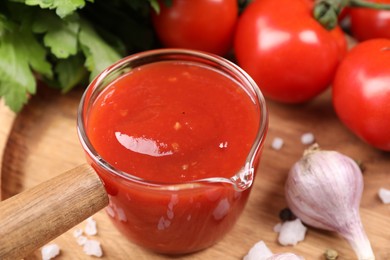 Photo of Delicious ketchup, salt and garlic on table, closeup. Tomato sauce