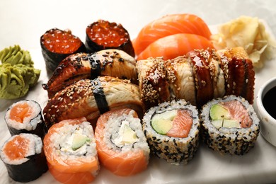 Photo of Set of delicious sushi rolls on board, closeup