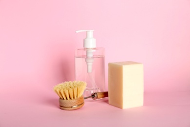 Cleaning supplies for dish washing on pink background