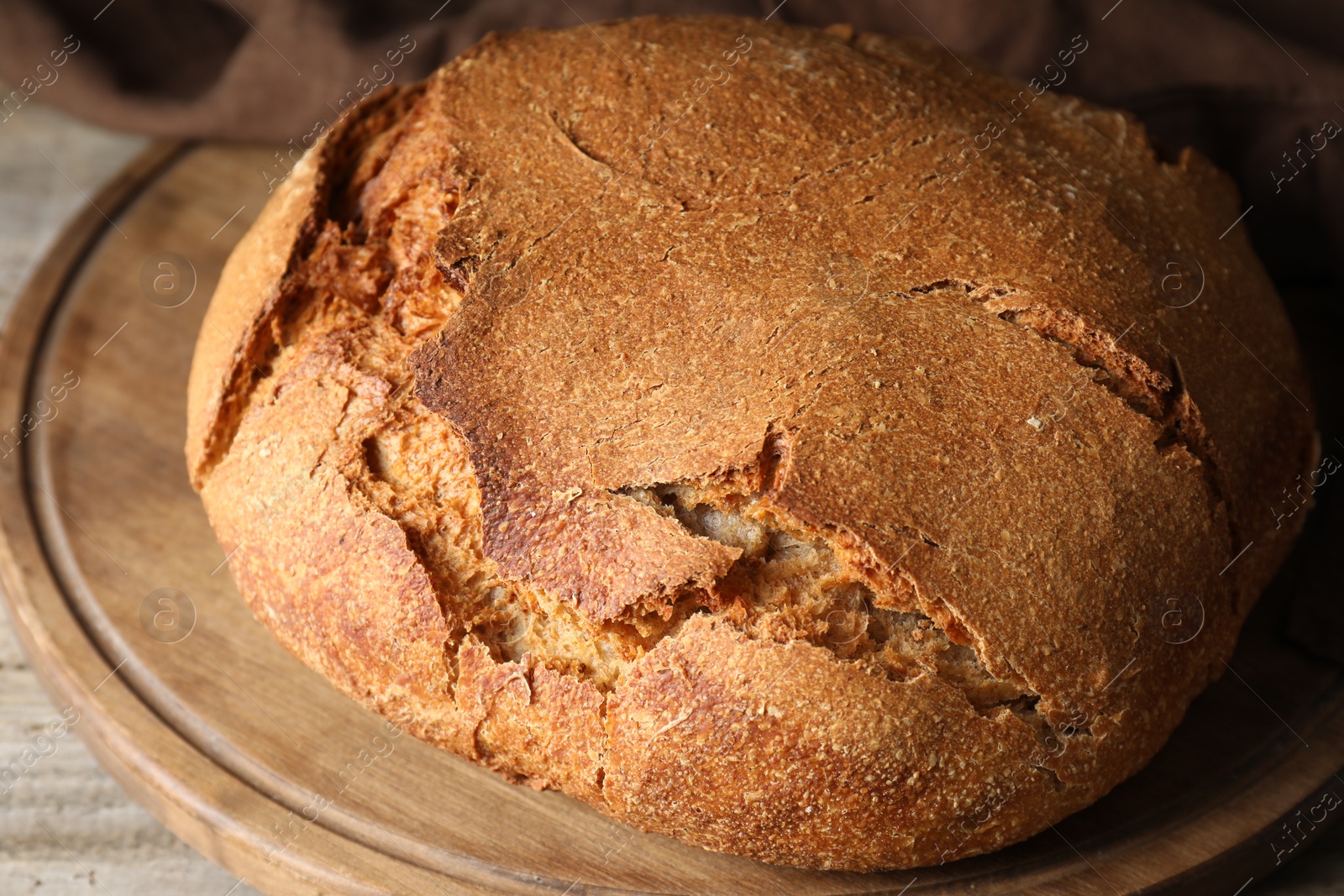 Photo of Freshly baked sourdough bread on wooden table, closeup