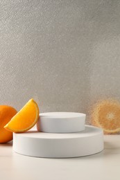 Presentation for product. Podium and tasty fresh oranges on white table, space for text