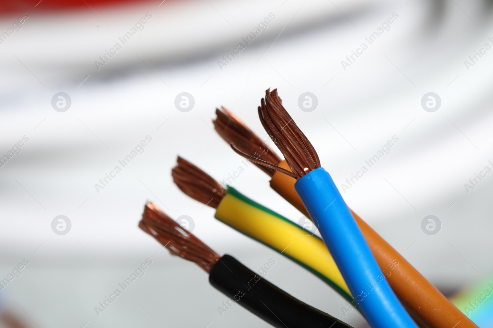 Photo of Colorful electrical wires on blurred background, closeup