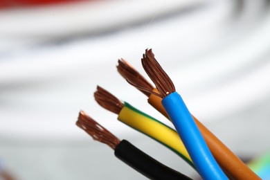 Photo of Colorful electrical wires on blurred background, closeup