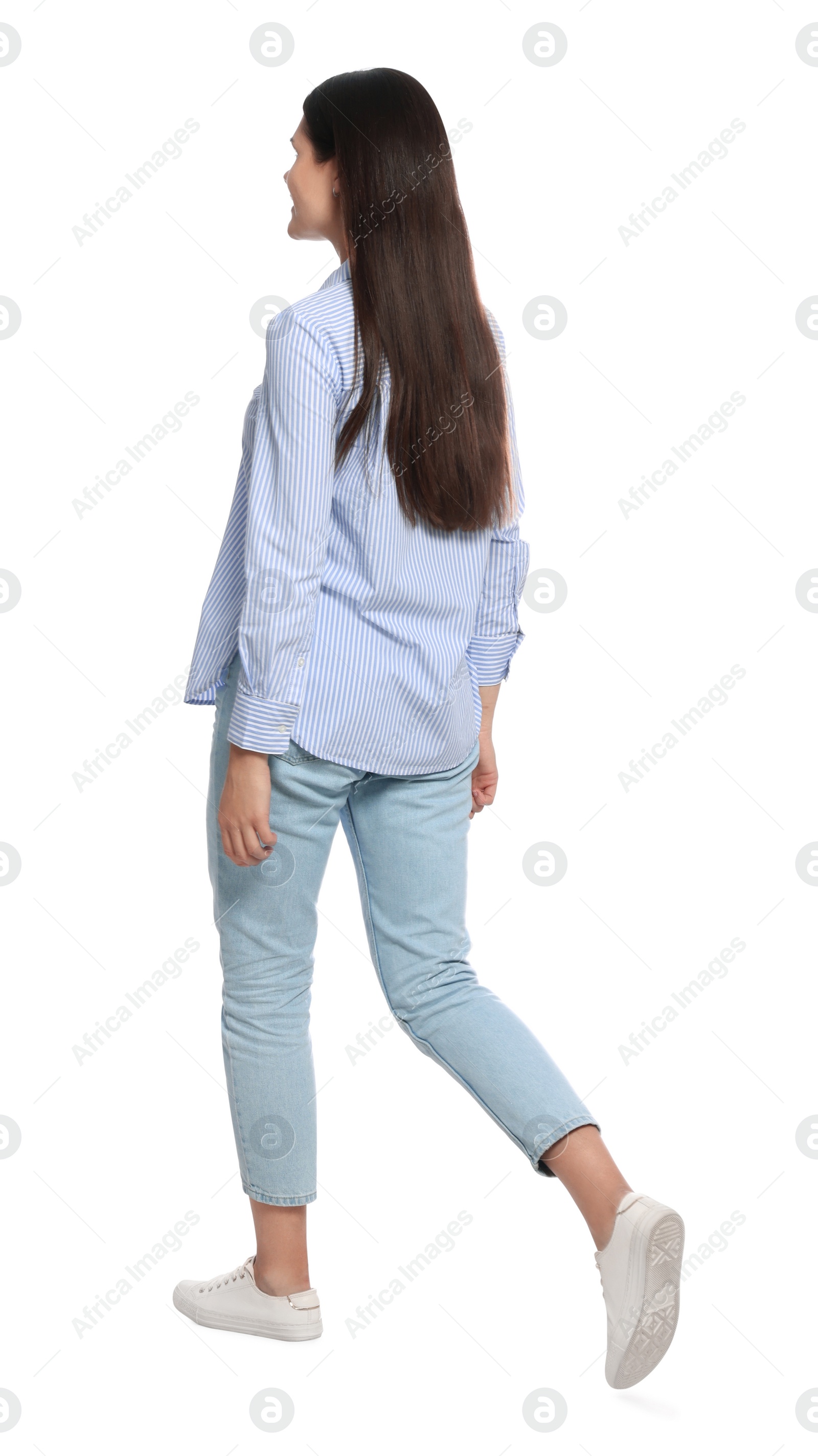 Photo of Young woman in stylish outfit walking on white background