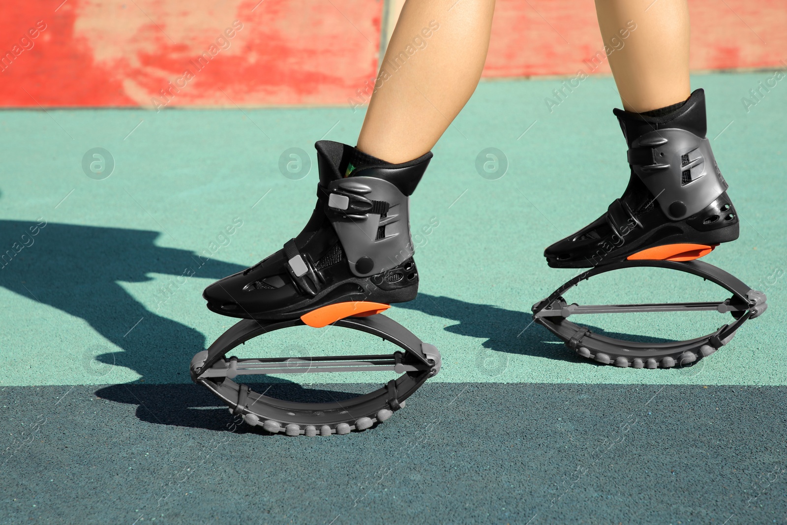 Photo of Woman with kangoo jumping boots in workout park, closeup