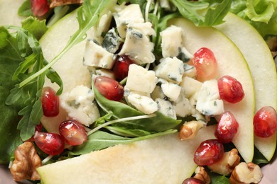 Photo of Tasty salad with pear slices, blue cheese and pomegranate seeds as background, closeup