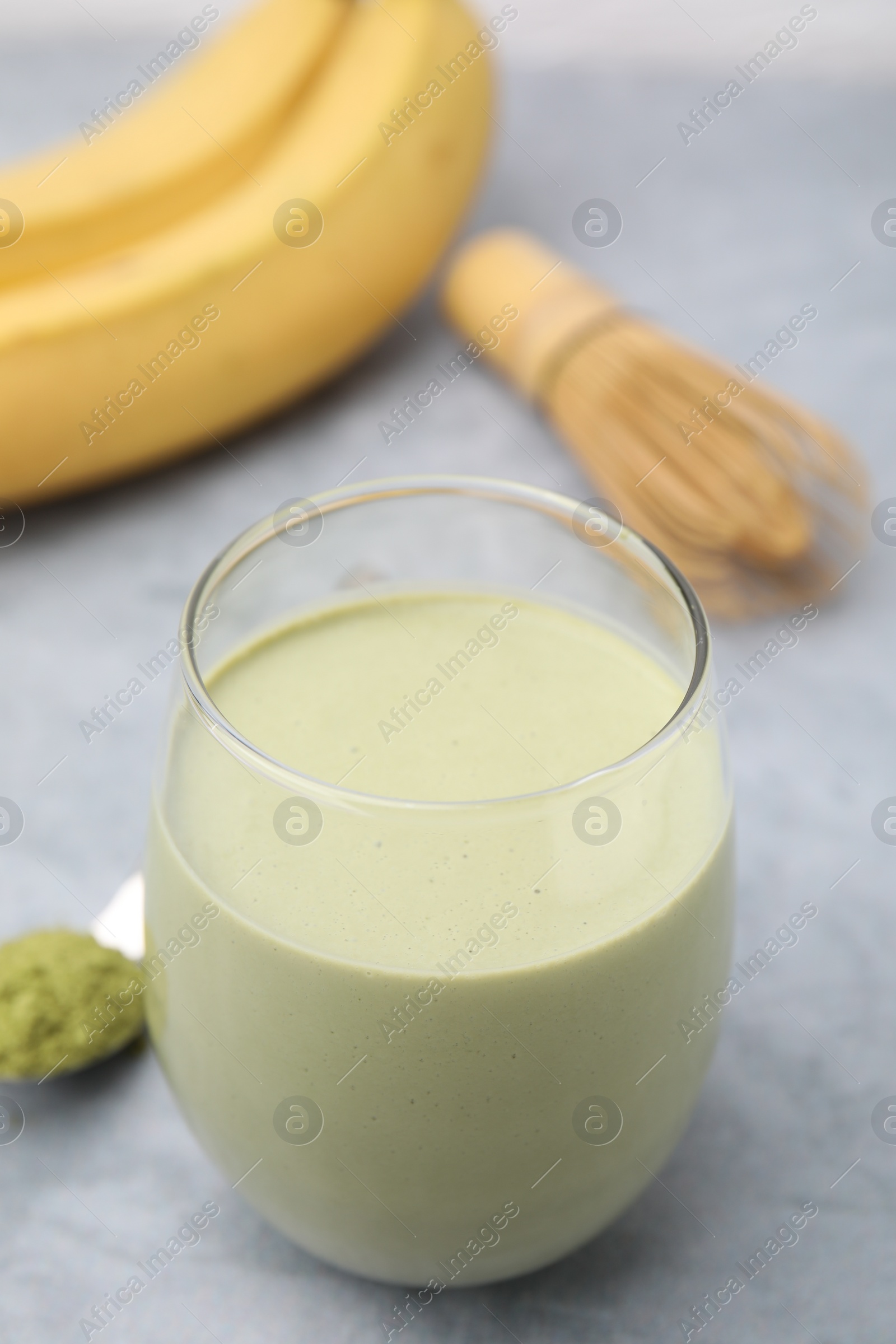 Photo of Glass of tasty matcha smoothie on light grey table