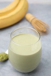 Photo of Glass of tasty matcha smoothie on light grey table