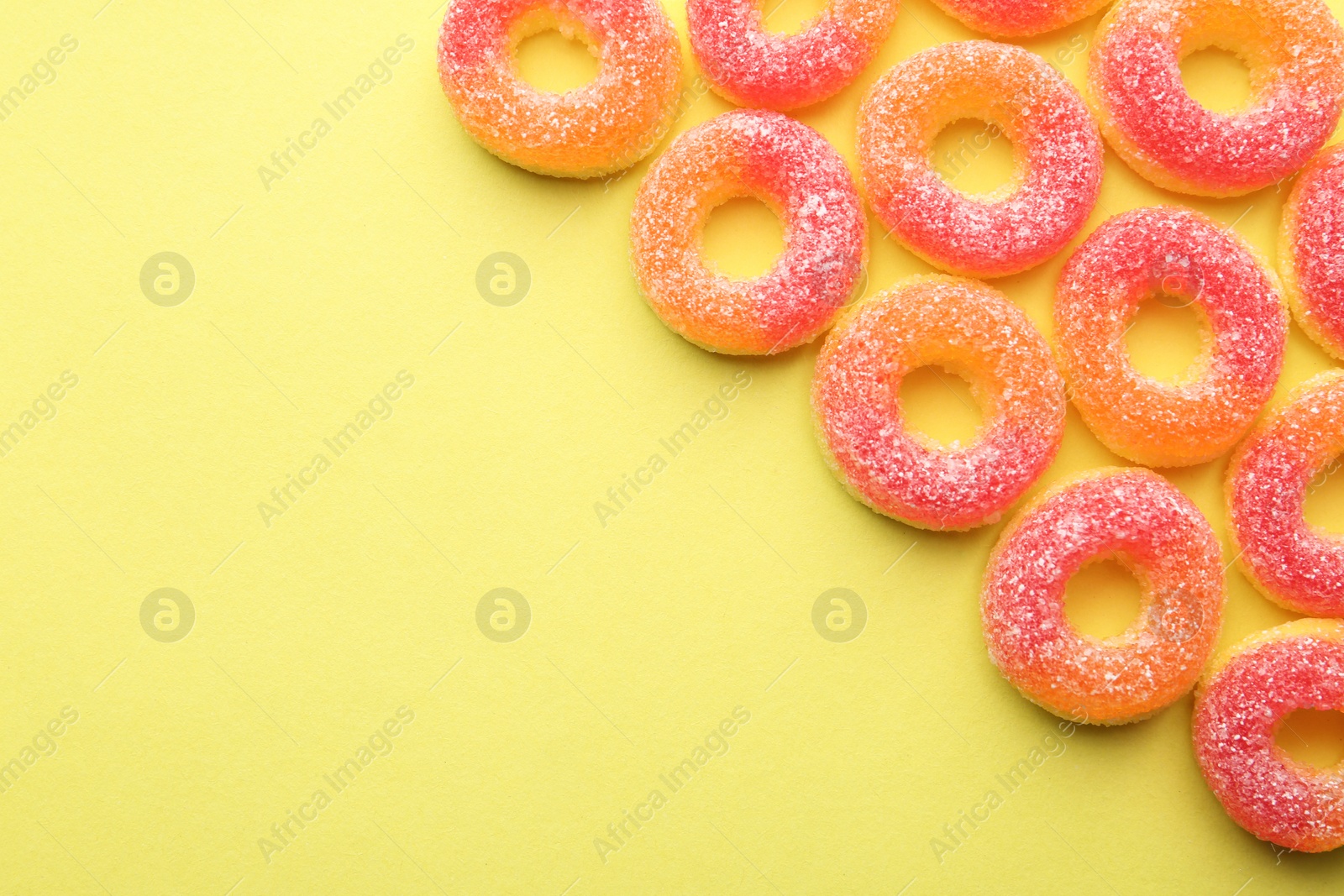 Photo of Tasty jelly candies on color background, flat lay. Space for text