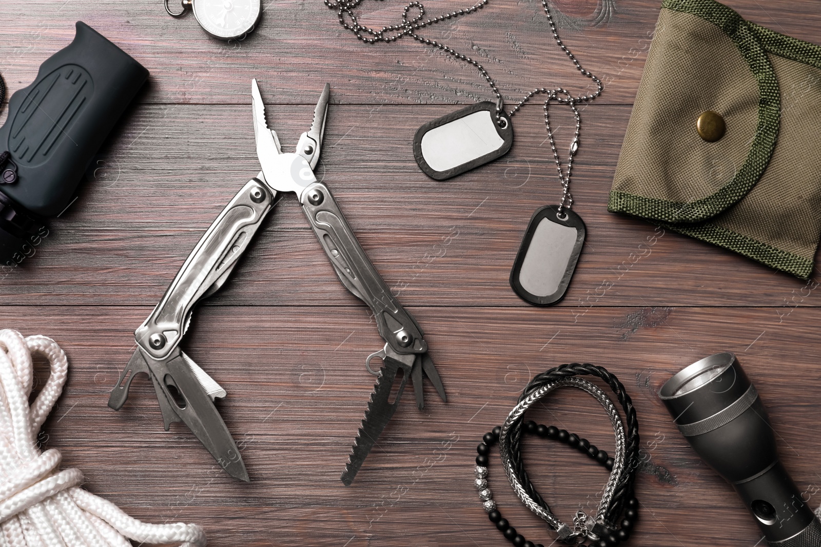 Photo of Flat lay composition with compact portable multitool and accessories on wooden table