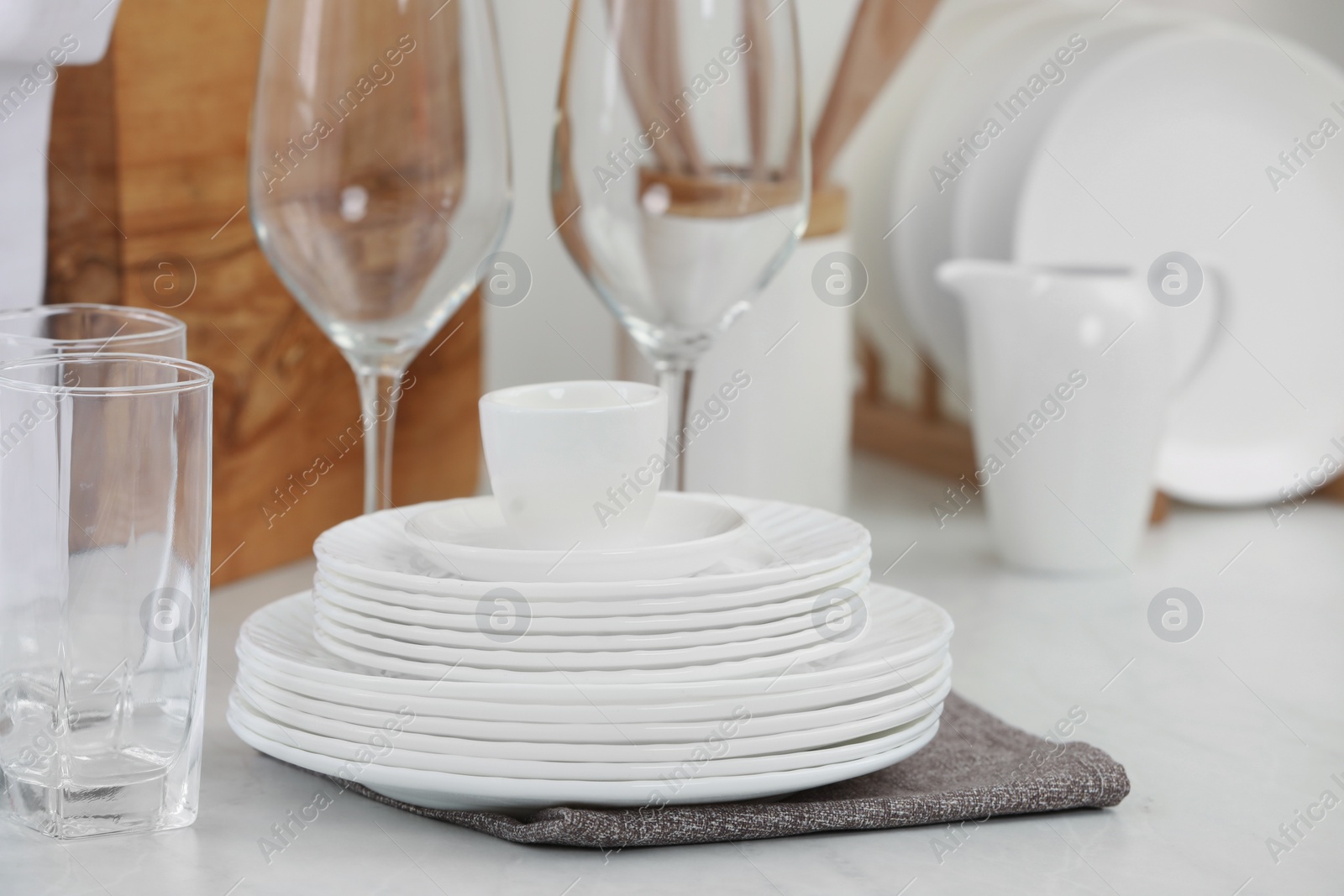 Photo of Clean dishes on light table in kitchen