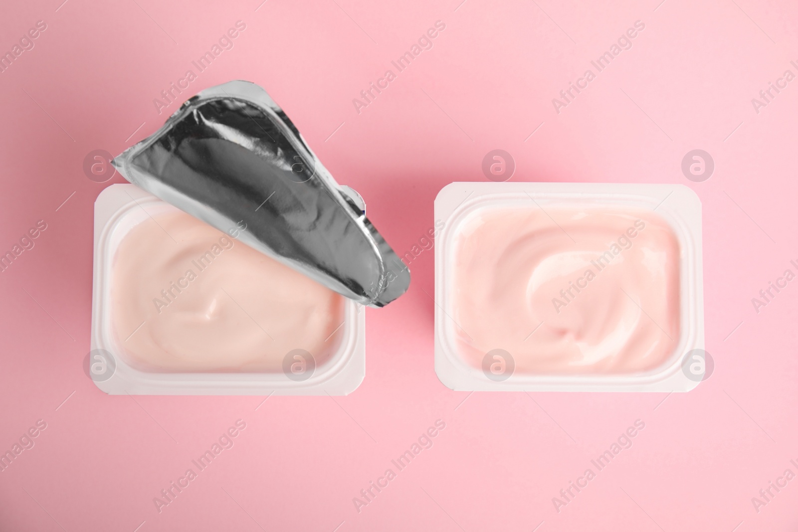 Photo of Tasty organic yogurt on pink background, flat lay