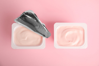 Photo of Tasty organic yogurt on pink background, flat lay