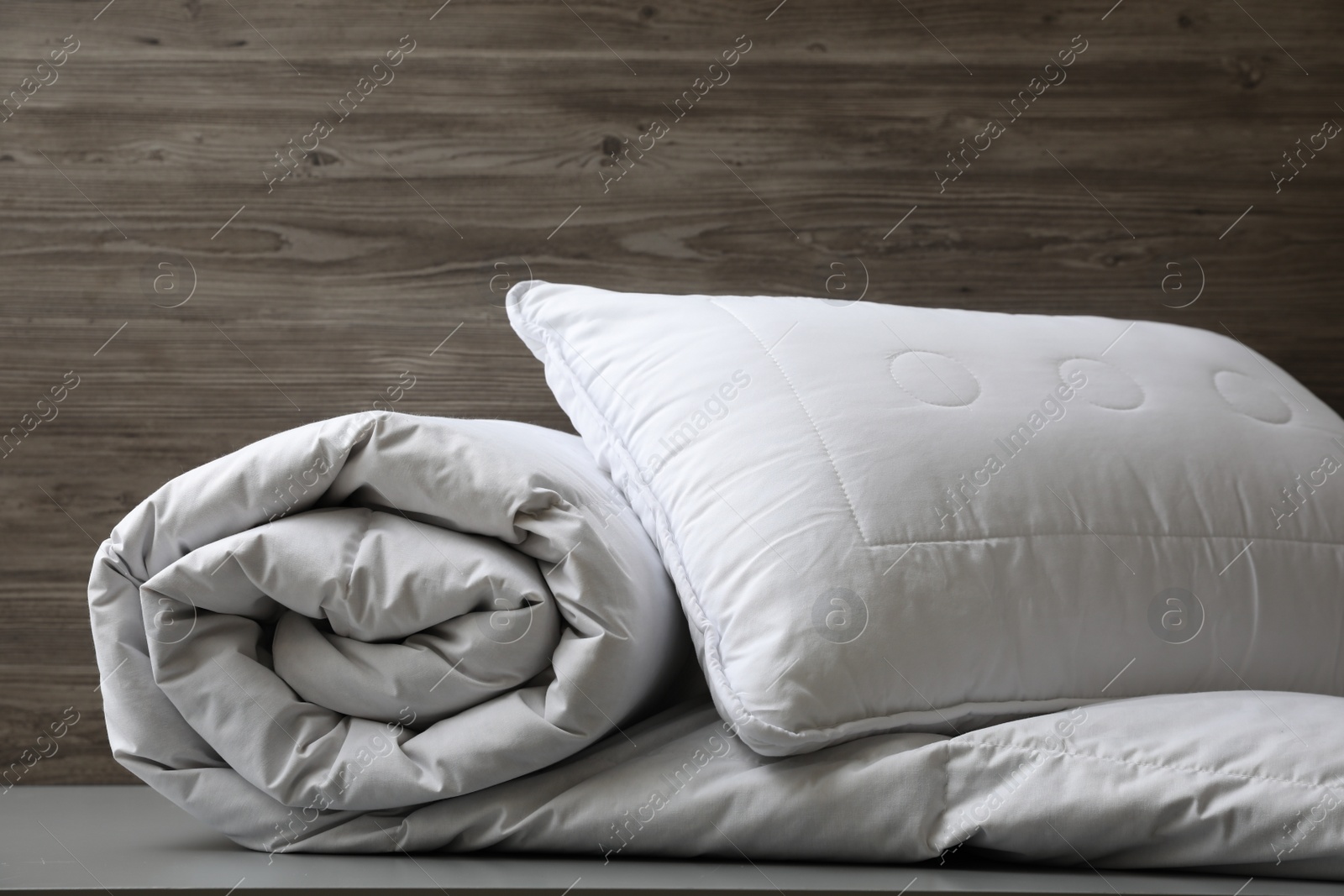 Photo of Soft blanket and pillow on light grey table